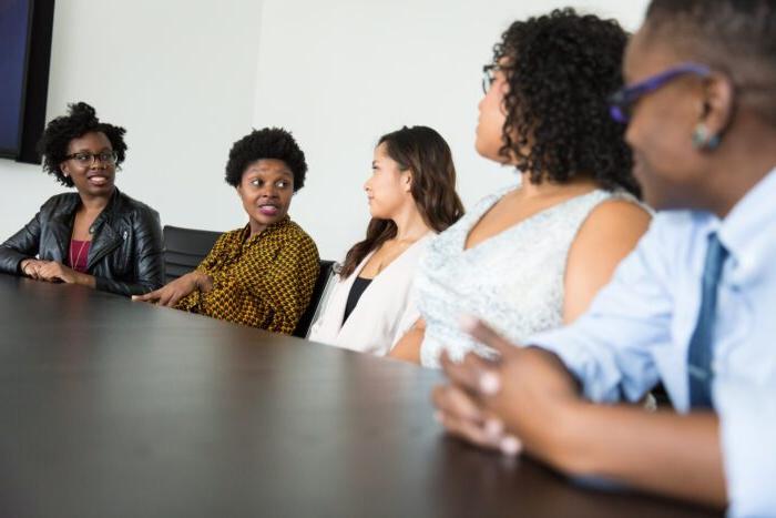 A group of consolers having a conversation siting down at a table.